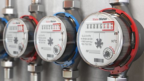 Row of water meters on a wall.