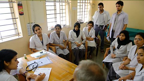 A room full of medical students being taught in a classroom.