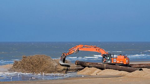 Beach nourishment - a digger moving sand on a beach