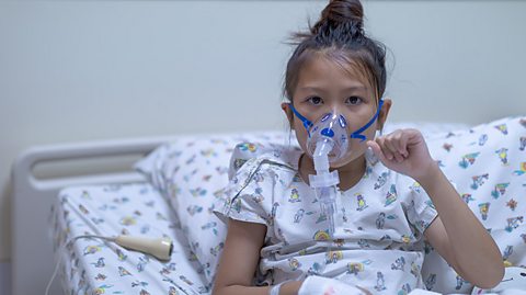 Girl with cystic fibrosis breathing through a Nebulizer mask