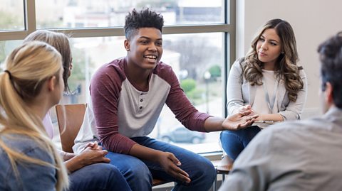 A black teenager shares his ideas with a group