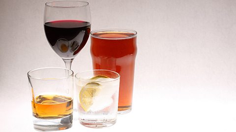 Four glasses containing different alcoholic drinks - wine, beer, whisky and gin 