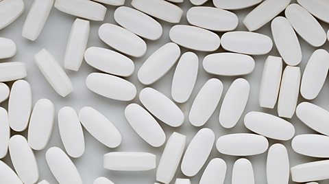 A photo showing lots of white pills 