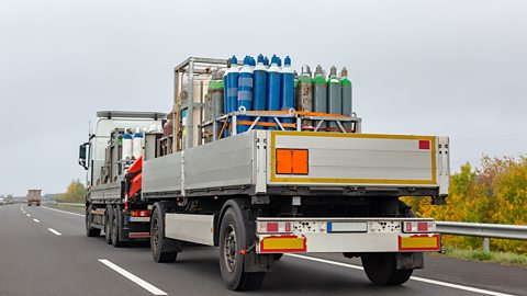 Cylinders containing compressed gas being transported by a truck