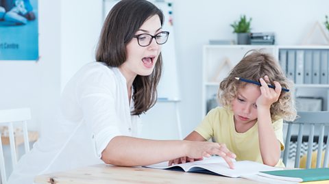 A teacher explaining something to a child