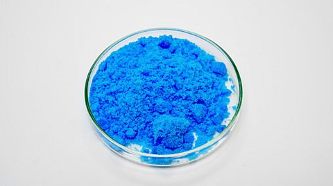 A dish of blue crystals of the substance copper sulfate