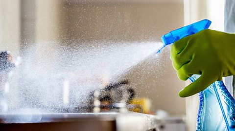 Sanitising spray being sprayed onto a work surface