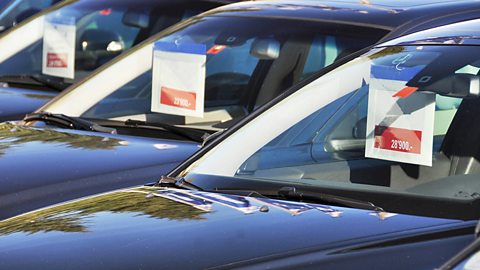 Several cars on sale with prices on the windscreens.