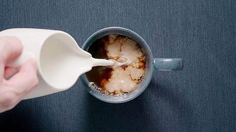 Milk being poured into a cup of tea