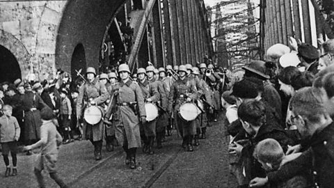 A black and white photo of German troops marching over the River Rhine into the Rhineland.