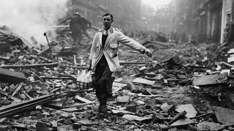 A black and white photograph of a milkman delivering milk among bombed houses and debris.