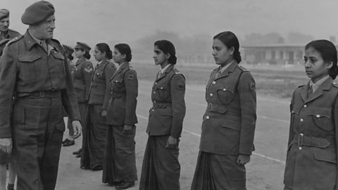 A black and white photograph of Field Marshal Sir Claude Auchinleck, a British Army commander, inspecting members of the Women’s Auxiliary Corps.