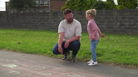 father and son playing hopscotch