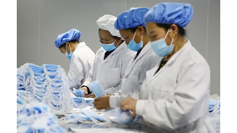 STR/AFP/Getty Images Chinese workers making masks (Credit: STR/AFP/Getty Images)