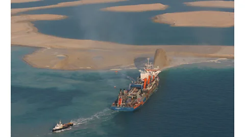 Getty A ship in the Persian Gulf pumping tonnes of sediment into the sea, gradually growing an island (Credit: Getty)