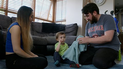 A family sits in their living room and plays a game of What's In The Bag.