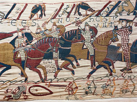 A cloth showing Normans with swords on horses charging.