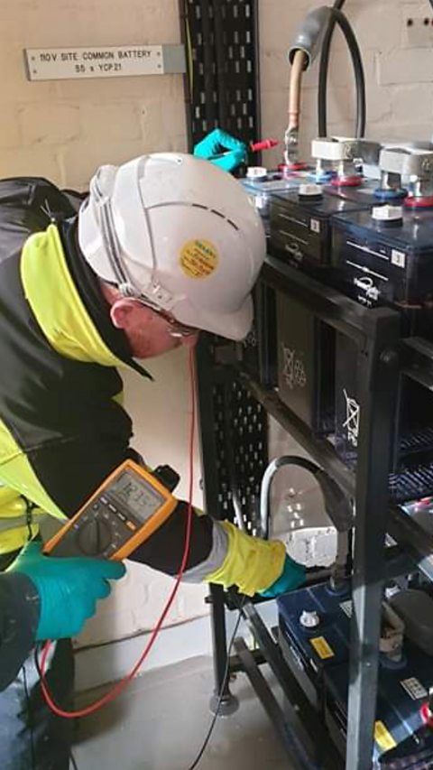 Adam is testing the voltage of a battery.