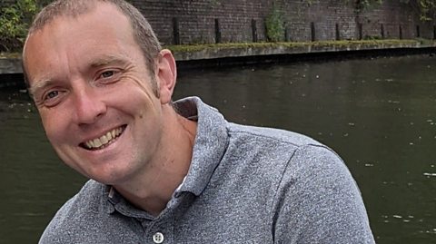 A photograph of primary school teacher Nathan Williams by a canal.