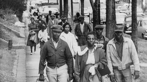 A group of people walking on the footpath to work