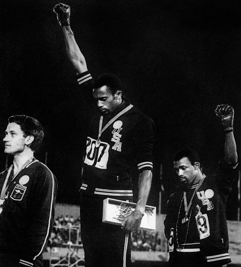 Tommie Smith and John Carlos raising their fists in the air, giving the Black Power salute on an Olympic podium