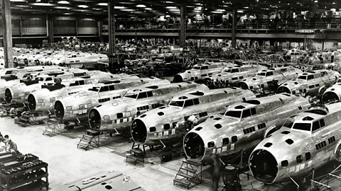 A photograph of rows of bomber aircraft being built in a factory