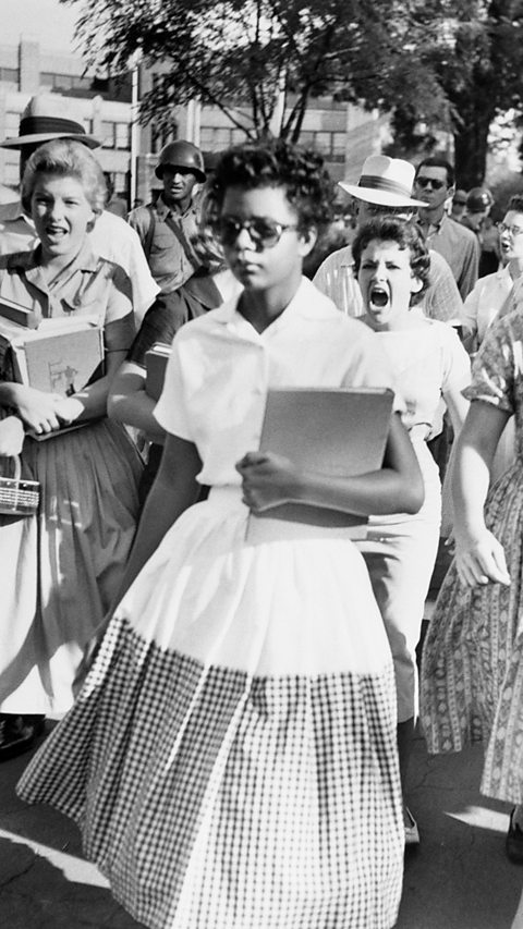 A photograph of Elizabeth Eckford walking as two women shout at her from behind