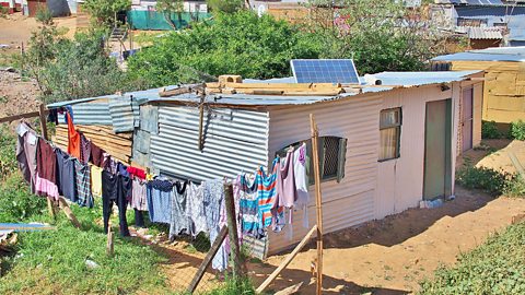  A small house with a solar panel on the roof.