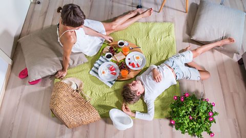 A mother and child enjoy an indoor picnic 