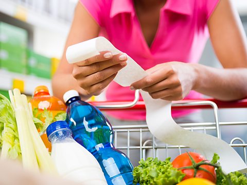 Checking a receipt for shopping in a supermarket trolley.