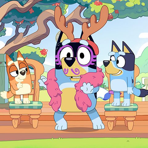 Bluey and his brother stand on a chair. His dad is doing some fancy dress up.