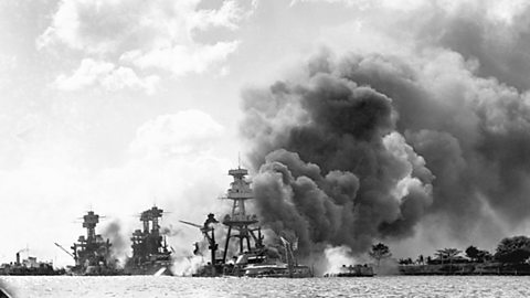 Burning ships floating in the sea off the coast of Hawaii