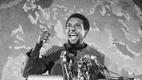 Stokely Carmichael stood behind a lectern giving a speech