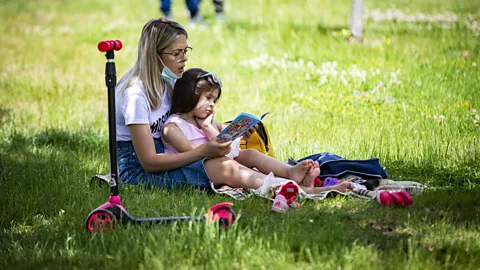 Ozge Elif Kizil/Anadolu Agency via Getty Images Reading together, like this mother and child in a park in Turkey, can boost children's language and literacy skills (Credit: Ozge Elif Kizil/Anadolu Agency via Getty Images)