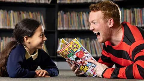 Matt Alexander/PA Wire World Book Day celebrates the joy of reading, and has become increasingly popular. Here, British Olympic Gold Medallist Greg Rutherford joins in (Credit: Matt Alexander/PA Wire)