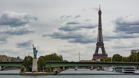 The replica Statue of Liberty in the shadow of the Eiffel Tower in Paris.