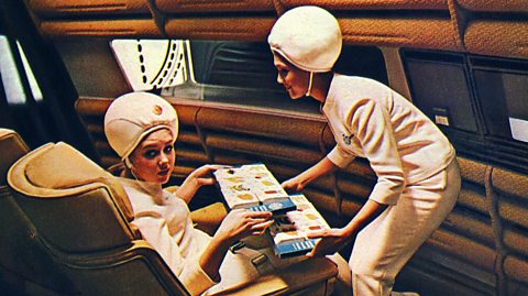 Two flight attendants in futuristic attire, including bobble hats.