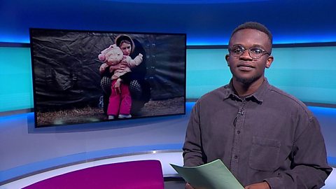 Newsround presenter De-Graft Mensah standing in the Newsround studio.