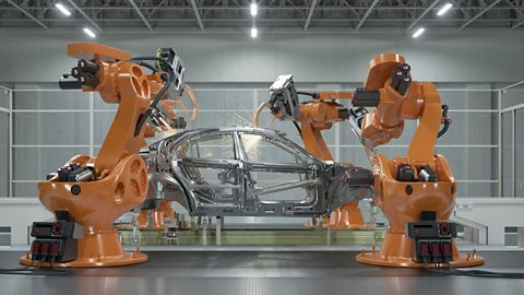 A photograph of robots welding a car body in a factory.