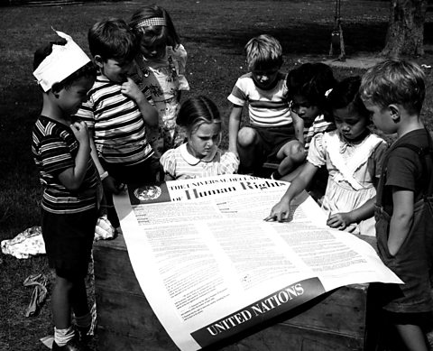 Children looking at a poster of the Universal Declaration of Human Rights, proclaimed in 1948