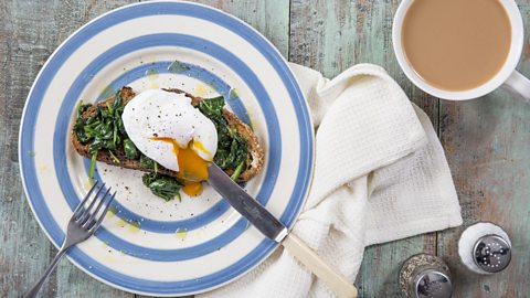 Are eggs healthy and how many calories are in them? A plate with wholemeal toast, spinach and poached egg on top, with a cup of tea to the side of the picture