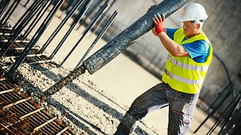 Reinforced concrete is made by pouring concrete around a mesh of steel cables.