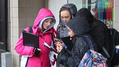 Students carrying our a survey using clipboards