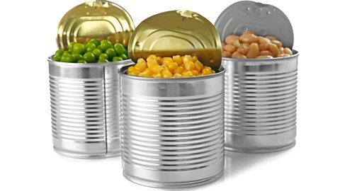 Three food cans containing peas, sweetcorn, and beans