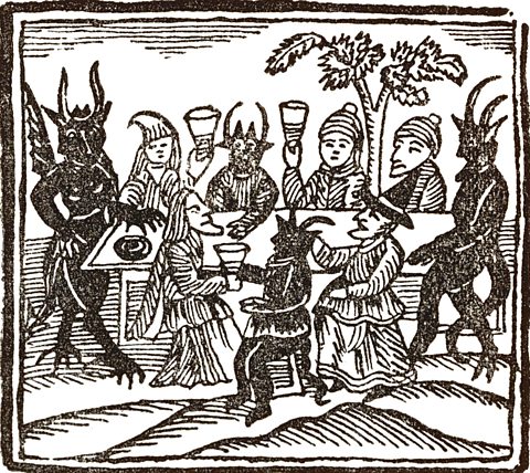 A woodcut about 1600 showing group of male and female witches drinking with horned devils.