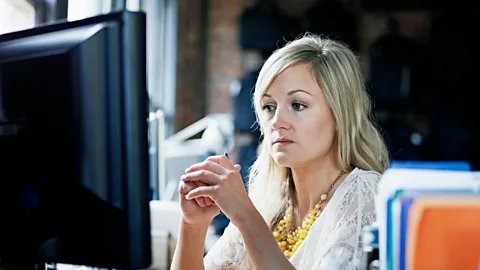 Getty Unhappy woman at office desk