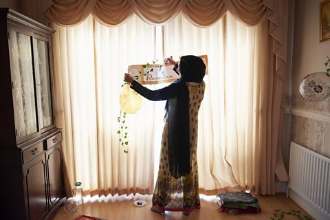 Young muslim woman decorating home for Ramadan gathering