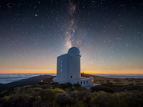 A starry night sky above an observatory tower.