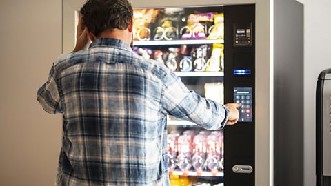 Night shift and rotational shift workers have it hardest person stands at a vending machine choosing a snack
