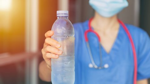 Poor break times A doctor/nurse holds up a bottle of water